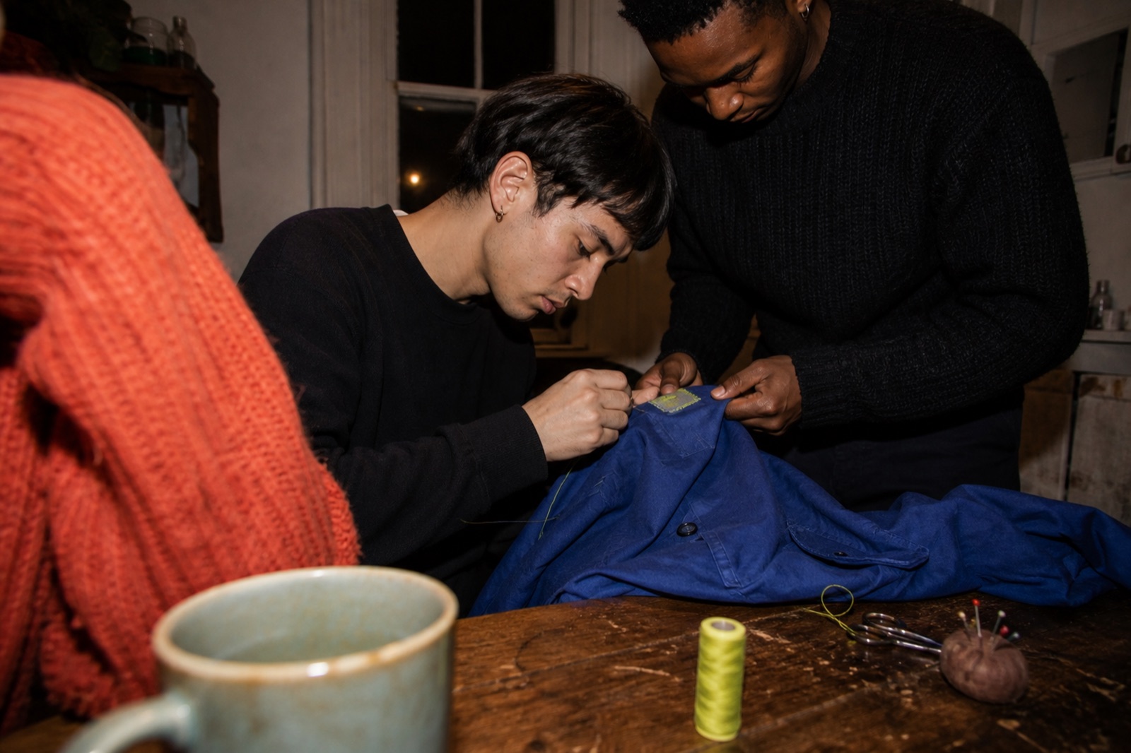 Friends repairing a cobalt garment together